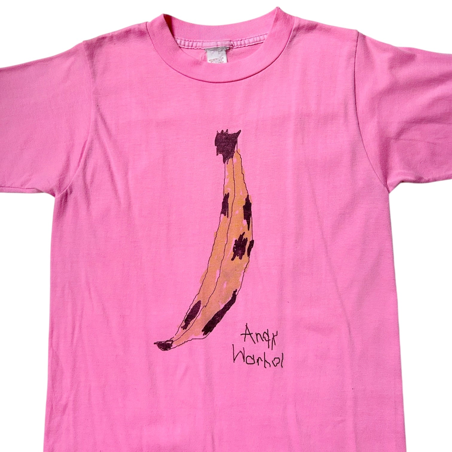 Pink t-shirt with a banana graphic and 'Andy Warhol' text on a white background